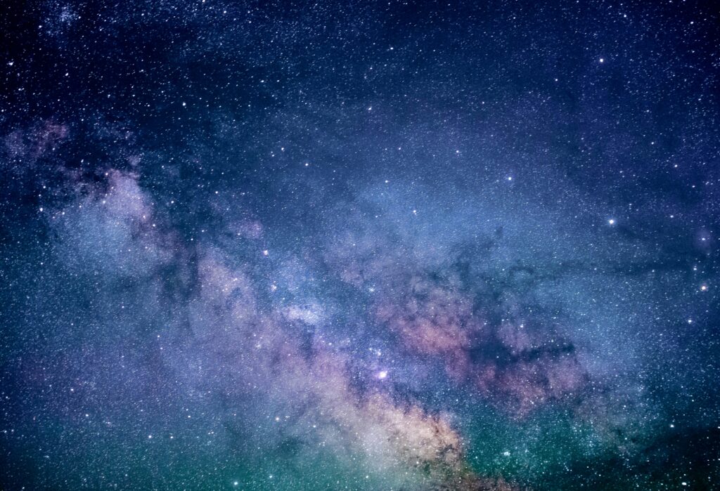 picture of universe with stars in dark blue to lighter blue in the middel and green and purple shades